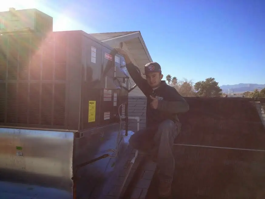 HVAC technician performing Heat Pump Repair on a rooftop unit in Seaford